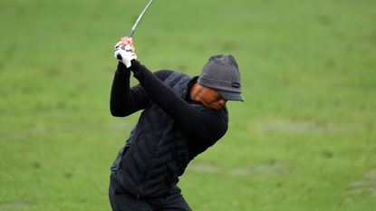 Tiger Woods hits a fairway wood on the range