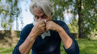 9 allergy season symptoms: Image shows man blowing nose