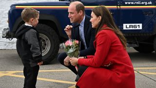Prince William, Prince of Wales gestures as his wife Catherine, Princess of Wales is presented with a posy of flowers