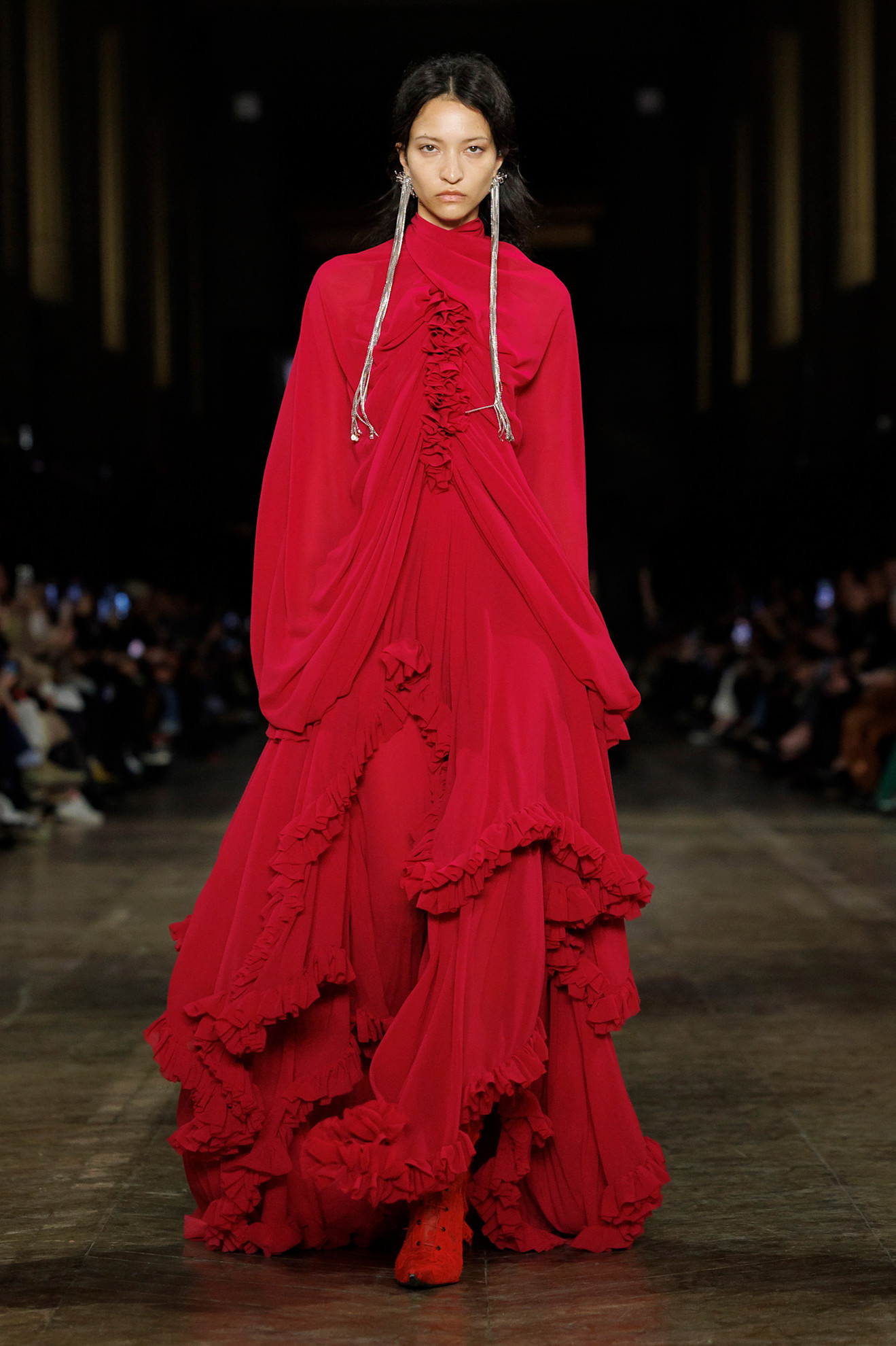 A model wears chili flake red on Alexander McQueen's fall 2025 runway
