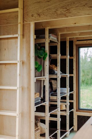 wooden wall shelving inside one of Common Knowledge's tiny homes or tigíns