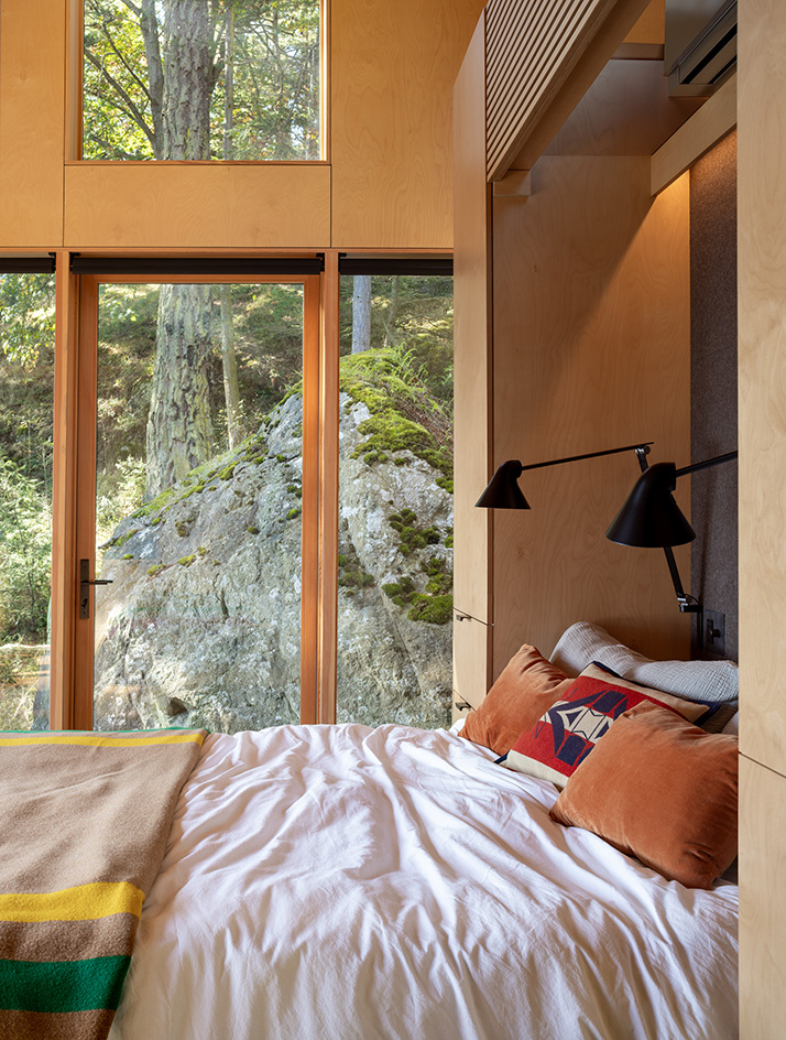 Blakely Island Cabin, a boxy structure raised on stilts above tree canopy in washington state forest