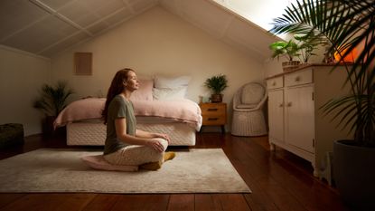 Woman doing yoga meditation in a bedroom