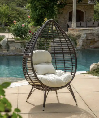 standing egg chair next to a pool