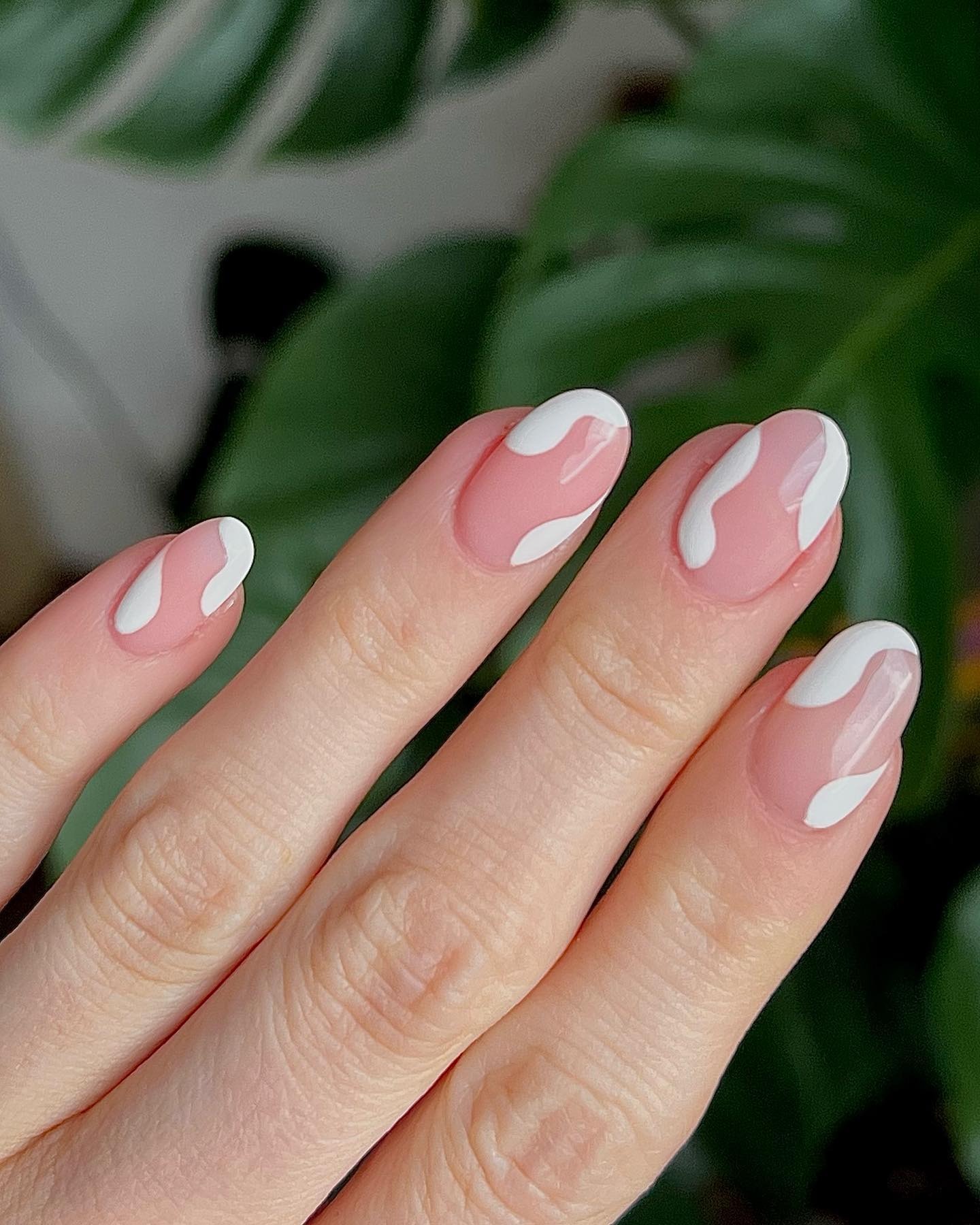 A clear manicure with white swirl detailing