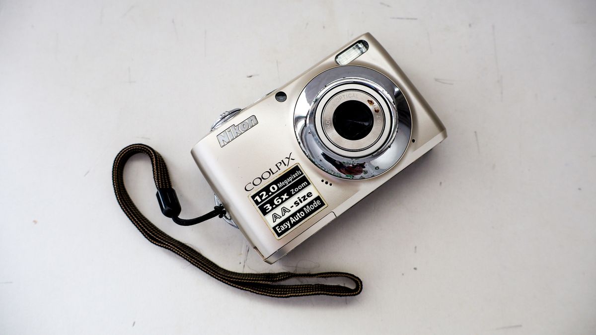 A silver Nikon Coolpix camera on a light colored background