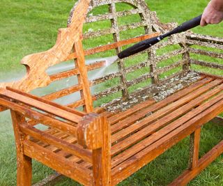 Cleaning moss and algae from a Lutyens bench with a pressure washer