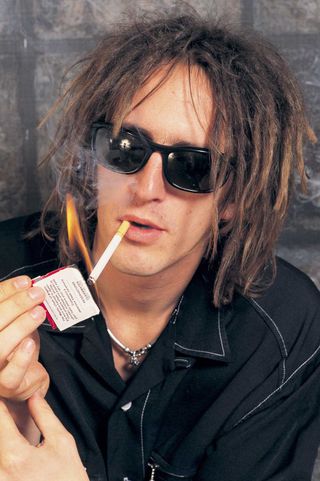 Izzy Stradlin lighting up a cigarette