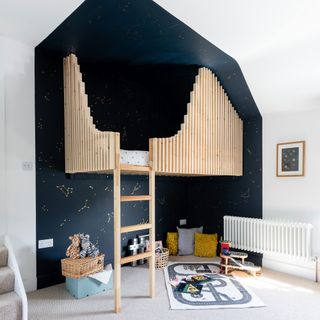 Boys bedroom with wooden cabin bed, painted shape wall with astronomy symbols,