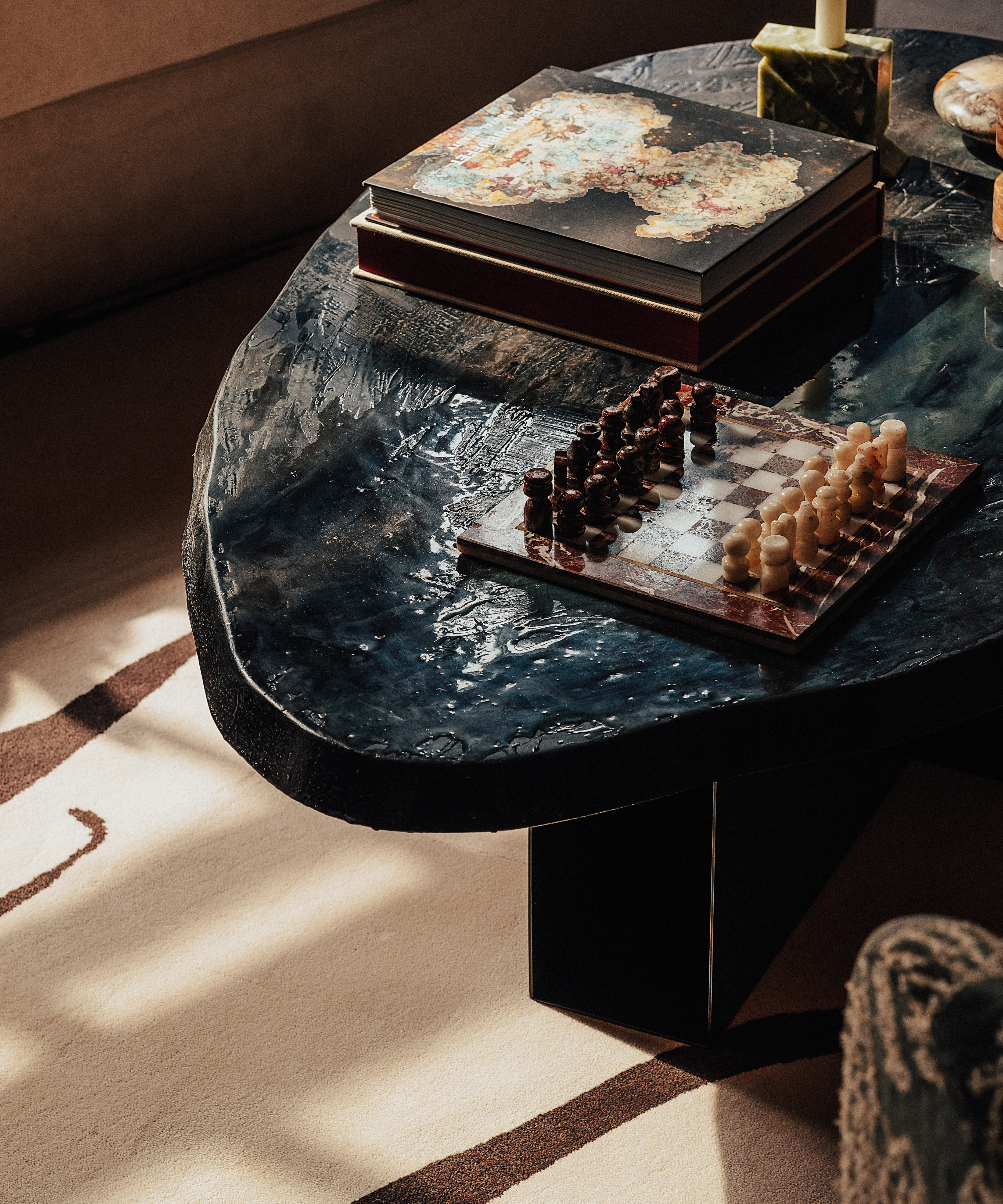 black glass coffee table with a chessboard and books on it