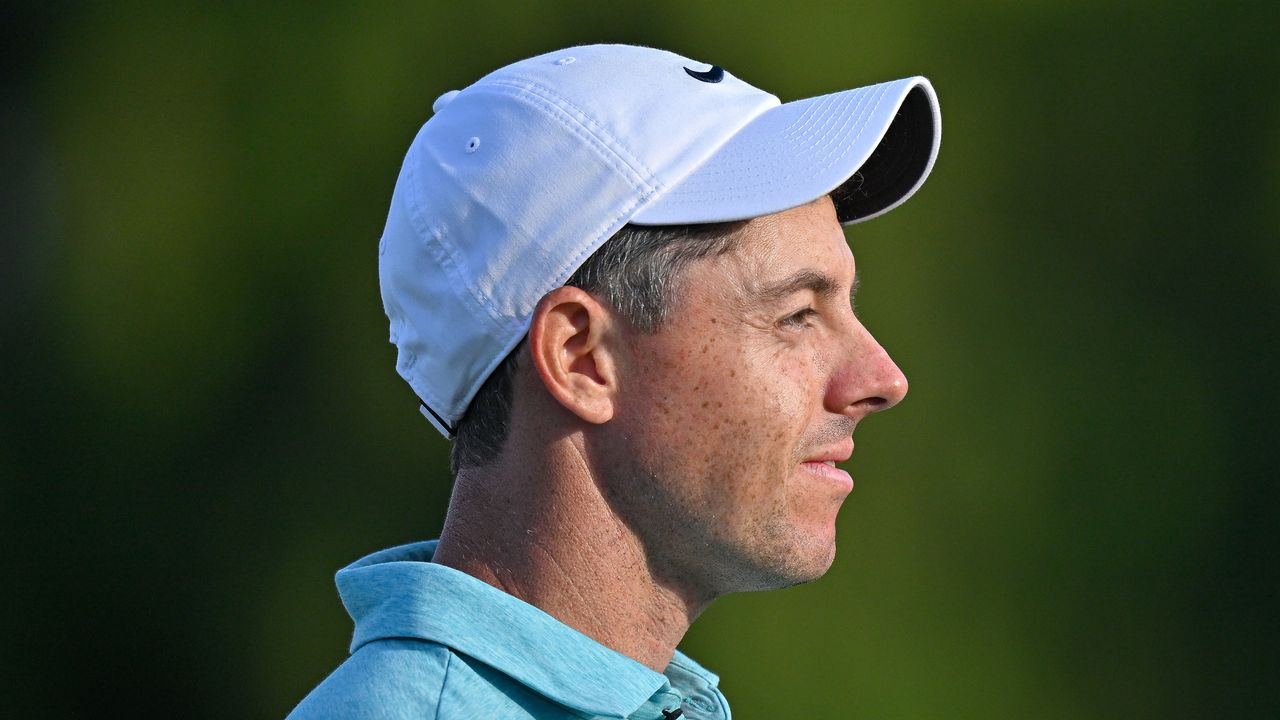 A close-up of Rory McIlroy looking to the right with a white Nike cap on