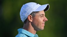 A close-up of Rory McIlroy looking to the right with a white Nike cap on