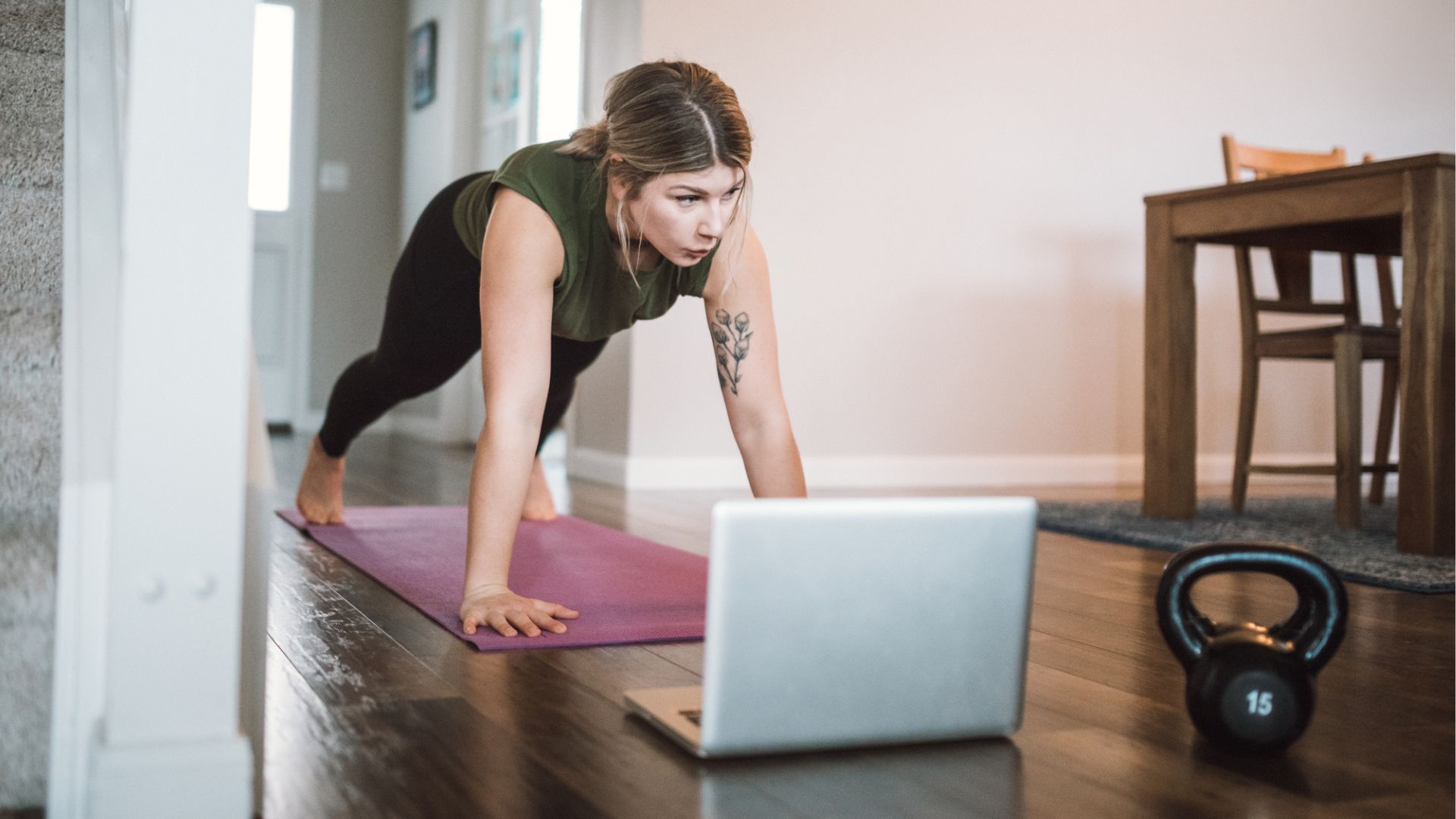 woman holds high plank at home 
