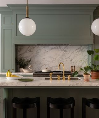 modern kitchen with dark green cabinets and marble backsplash