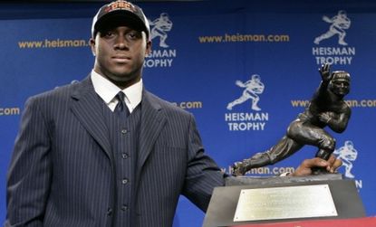 Reggie Bush, former running back for the USC Trojans, poses with the 2005 Heisman trophy.