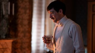 Blake Ritson holds a drink with concern in The Gilded Age.