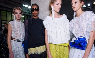 The models wore black and white dresses with pompom earrings.