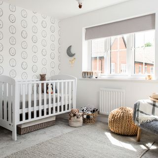 toy in white wooden crib and stickers on the wall