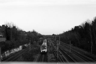 Train on tracks seen from a railway bridge taken on Ilford HP5 Plus 35mm film
