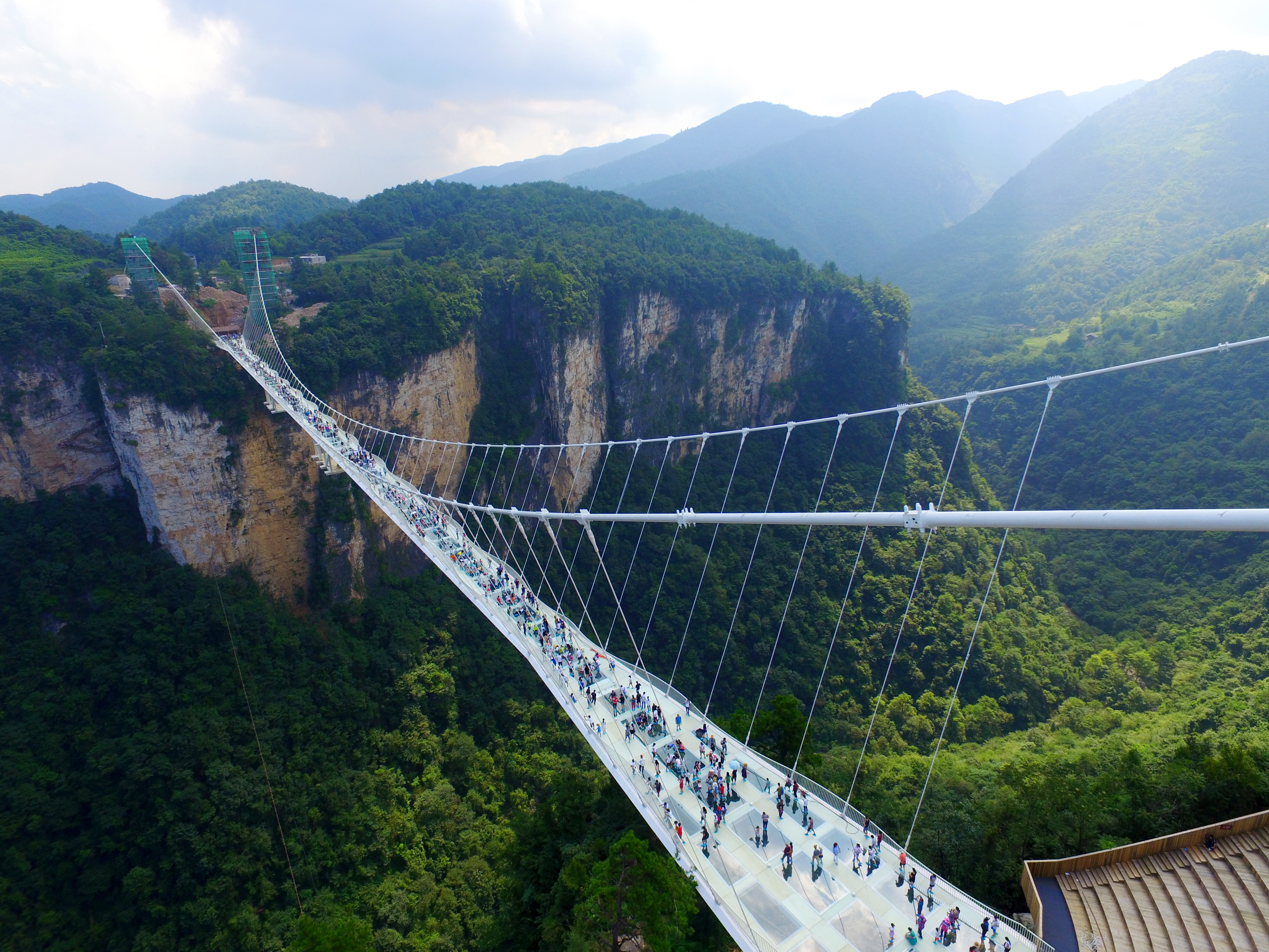 People walk across the Zhangjiajie Glass Bridge in China