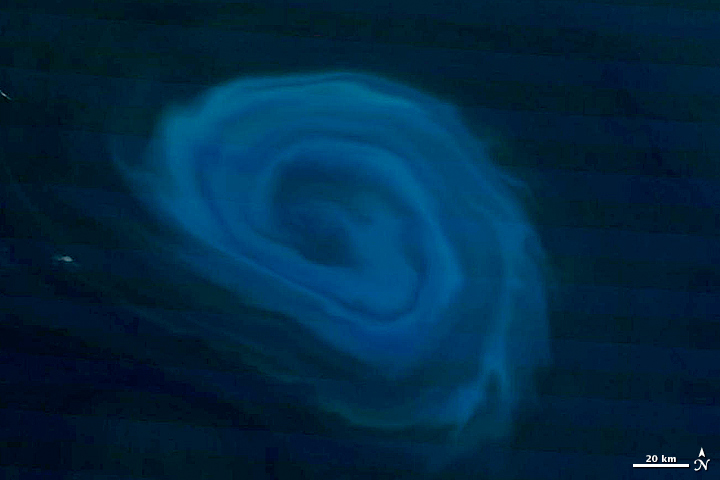 The Moderate Resolution Imaging Spectroradiometer (MODIS) on NASA’s Terra satellite captured these natural-color images of a deep-ocean eddy on December 26, 2011. The top close-up shows the vortex structure of the eddy, traced in light blue by plankton bl