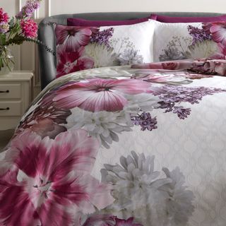 bedroom with contemporary florals and cushions on bed