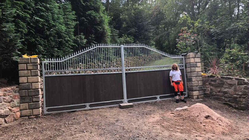 A large set of metal gates with a woman standing in front of them
