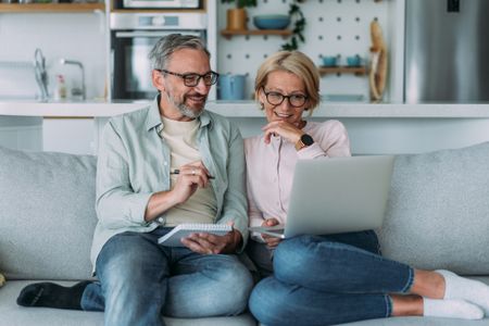 Shot of a lovely mature couple reviewing their finances while using laptop.