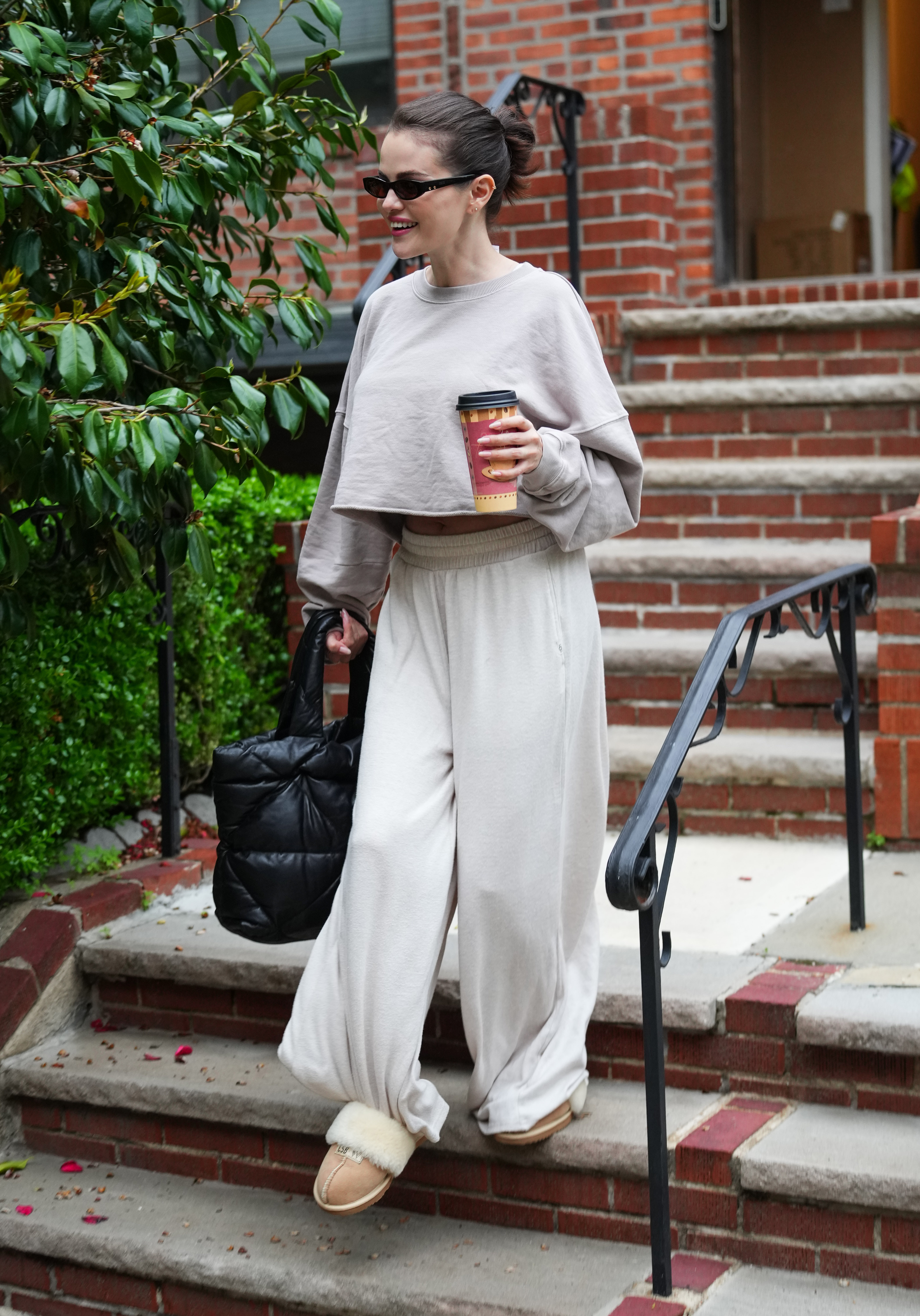 Selena Gomez wearing a gray hoodie, gray sweatpants, and shearling-lined slippers in New York City on May 7.