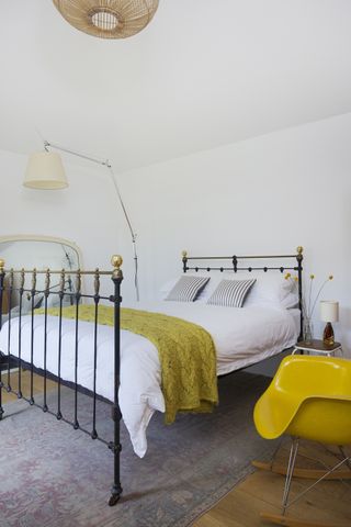 bedroom_white_iron_bed_yellow_chair_lamp_light_rug