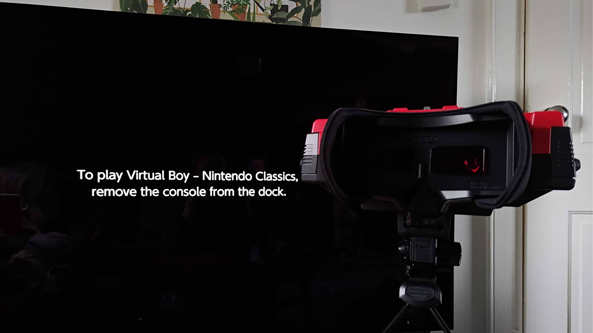 Virtual Boy with TV in backdrop displaying Switch 2 message that reads "To play Virtual Boy - Nintendo Classics, remove the console from the dock."