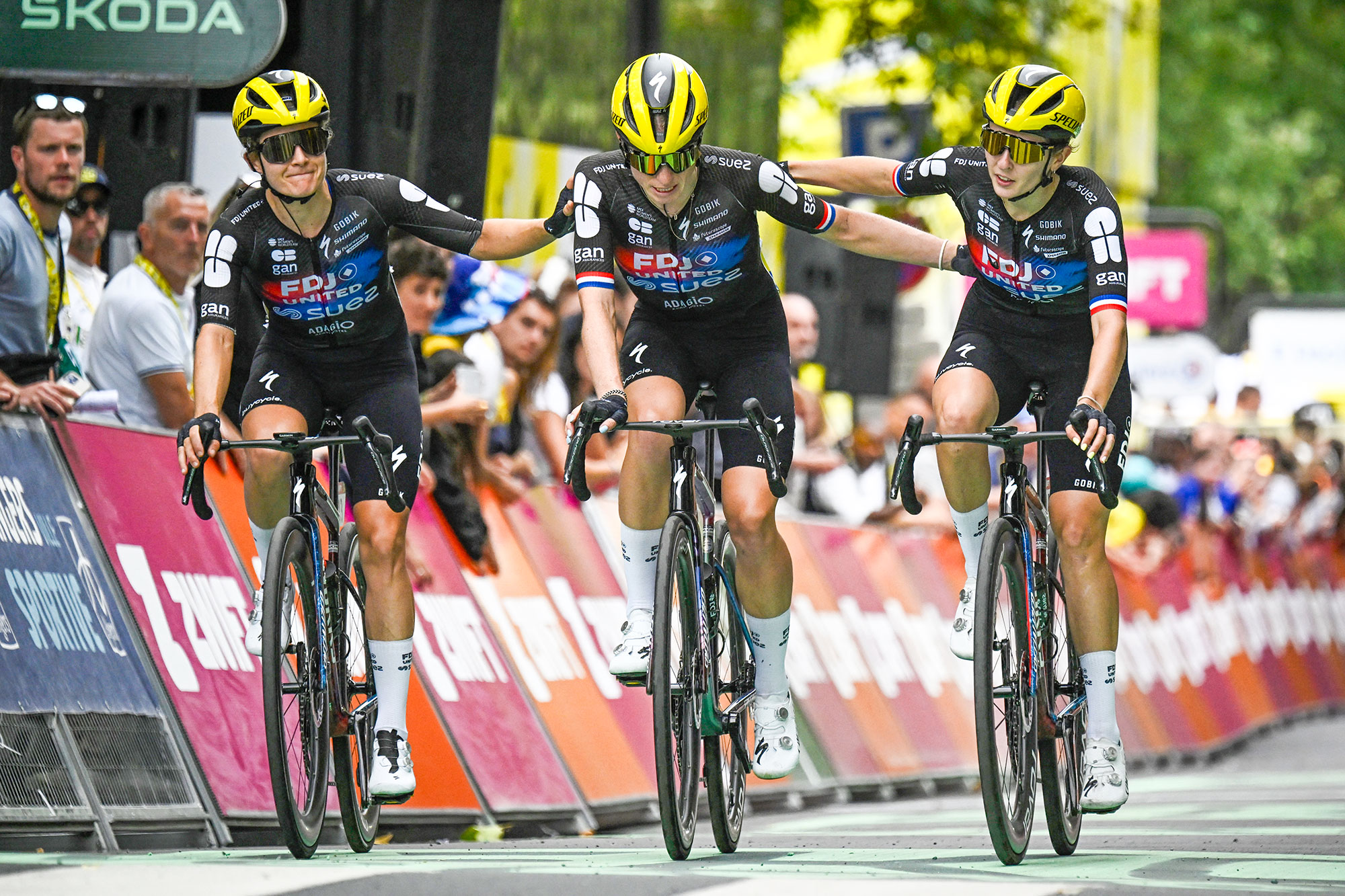 FDJ-SUEZ team's Dutch rider Demi Vollering (C) crosses the finish line as she is accompanied by her teammates FDJ-SUEZ team's Dutch rider Amber Kraak (L) and FDJ-SUEZ team's French rider Juliette Labous (R) after a fall during the 3rd stage (out of 9) of the fourth edition of the Women's Tour de France cycling race, 163.5 km from La Gacilly to Angers, in Angers, western France on July 28, 2025. The end of the stage 3 was marked by the heavy fall 3,700 meters from the finish line of the favorite of the event, the Dutchwoman Demi Vollering, who took time to get back up but was classified in the same time as the first competitors, the fall having occurred in the "sprint zone" of the last five kilometers. (Photo by JULIEN DE ROSA / AFP)