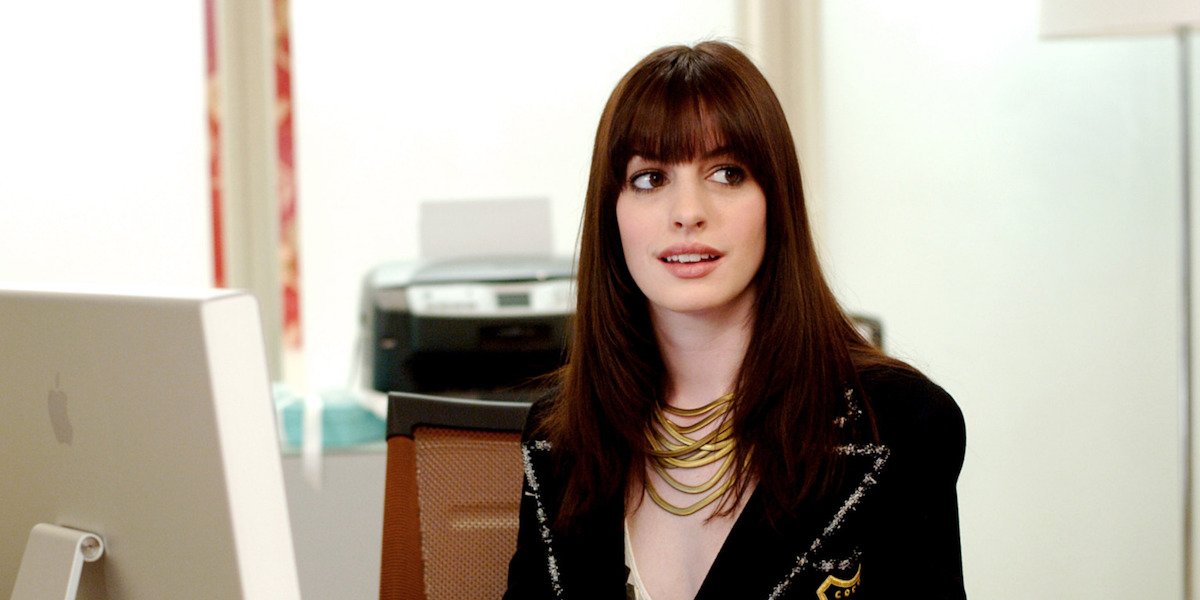 Andy (Anne Hathaway) sits at a desk in &#039;The Devil Wears Prada&#039;