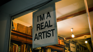 Sign in a shop window that reads 'I'm a real artist'