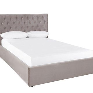 grey bed with buttoned headboard and white mattress