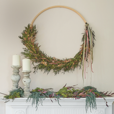 Sophisticated Christmas decorations, with metallic and magical finishes, modern wreath ring, above a mantlepiece and fireplace