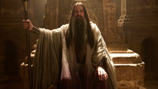 Ciarán Hinds as the "Dark Wizard" holding a staff.