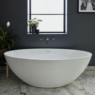 Bathroom with white bath tub and marble floor tiles