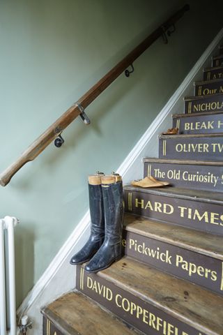 riding boots on stair case with book titles