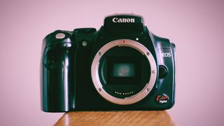 Canon EOS Kiss Digital sitting on a wooden surface