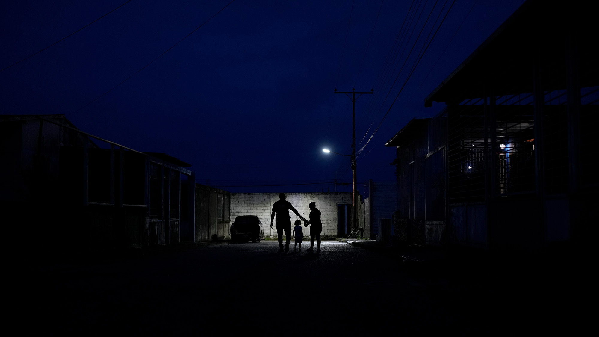 A family silhouetted on a dark street