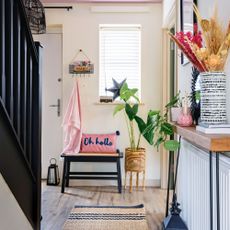 Radiator shelf over a radiator against a white wall decorated with a lamp, vase and candle