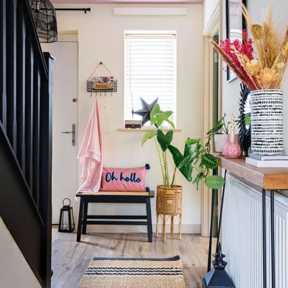 Radiator shelf over a radiator against a white wall decorated with a lamp, vase and candle