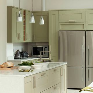 Green and white kitchen with stainless steel fridges