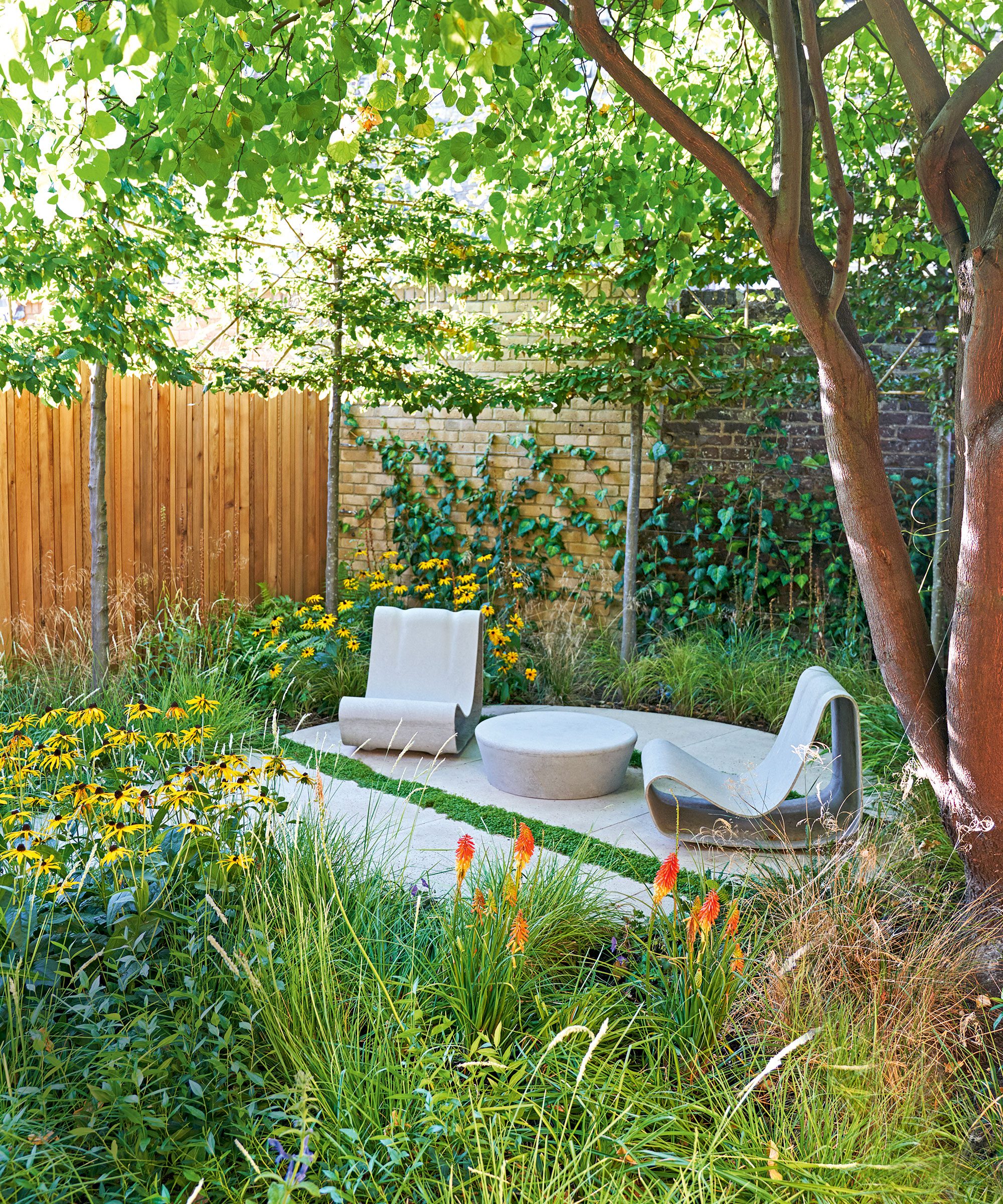 Garden trends with outdoor furniture, two curvaceous lounge chairs and coffee table on round patio