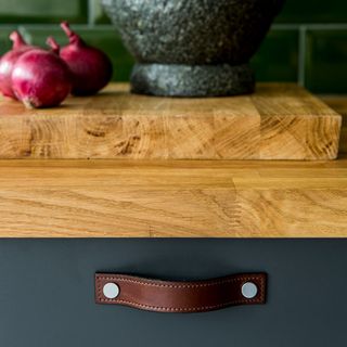 kitchen with wooden worktop and leather pull handles
