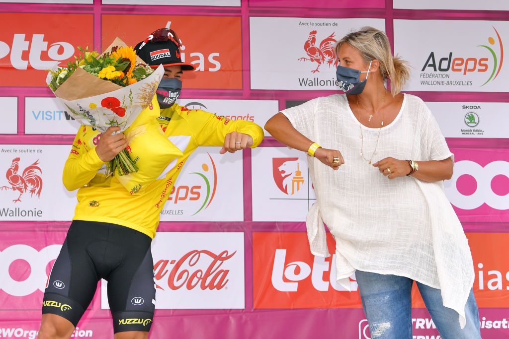 TEMPLEUVE BELGIUM AUGUST 16 Podium Caleb Ewan of Australia and Team Lotto Soudal Yellow Leader Jersey Celebration Hostess Flowers Covid safety measures during the 41st Tour de Wallonie 2020 Stage 1 a 187km stage from Soignies to Templeuve TourdeWallonie TRW2020 on August 16 2020 in Templeuve Belgium Photo by Luc ClaessenGetty Images