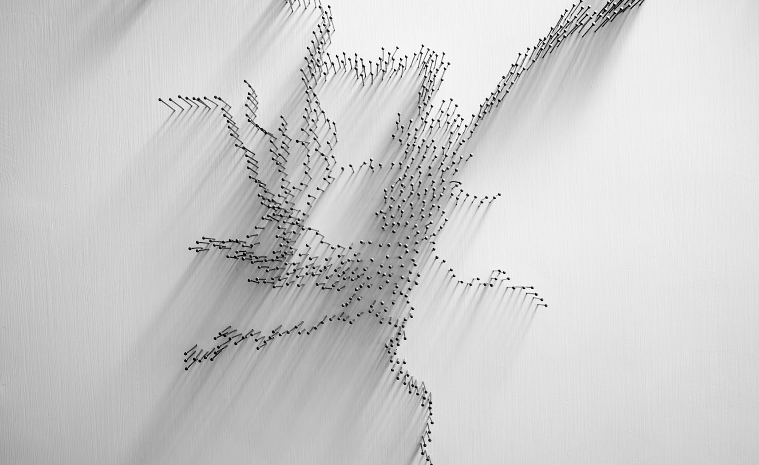 White background, close up of a series of tightly pinned steel pins to form part of the river artwork
