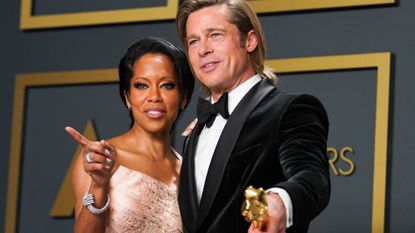 Regina King and Brad Pitt holding his Oscar award.