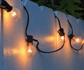 String lights on a white painted fence